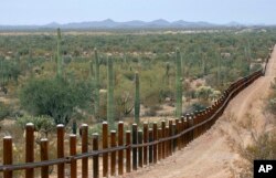 FILE - The international border line made up of bollards separating Mexico, left from the United States, in the Organ Pipe National Monument near Lukeville, Ariz., Feb. 17, 2006.