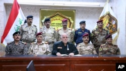 This photo released on his official Facebook page shows Iraqi Prime Minister Haider al-Abadi, center, surrounded by top military and police officers as he announces the start of the operation to liberate the northern city of Mosul from Islamic State militants, Oct. 17, 2016.