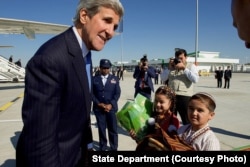 Children greet Kerry with traditional gifts of bread and salt at Turkmenistan's Ashgabat International Airport, Nov. 3, 2015.