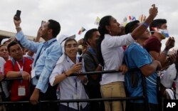 People take pictures as Pope Francis arrives at Tocumen international airport in Panama City, Jan. 23, 2019.