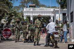 FILE - Senegalese soldiers check a motorcyclist at the entrance of the State House compound in Banjul, Gambia, Jan. 24, 2017. ECOWAS troops have moved into the State House to prepare for the return of President Adama Barrow.
