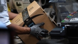 FILE - A worker assembles a box for delivery at the Amazon fulfillment center in Baltimore, Maryland, April 30, 2019.