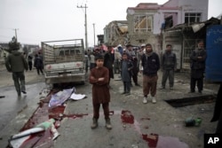 Residents walk through the site of a suicide attack in Kabul, Afghanistan, March 2, 2018. A large explosion in the eastern part of the Afghan capital on Friday morning killed at least one and wounding others officials said.