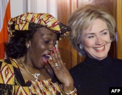 FILE - Nana Konadu Agyeman-Rawlings (L), wife of Ghana's President Jerry John Rawlings, speaks with first lady Hillary Rodham Clinton during an official state dinner at the White House, February 24, 1999.
