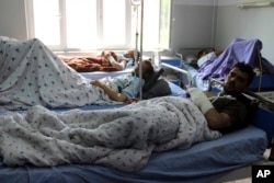 Injured men receive treatment at a hospital after a clash between Taliban and security forces in Kunduz province, Afghanistan, April 13, 2019.