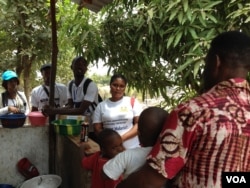 Zero Ebola Campaign volunteers, including Mary Kargbo (center), talk to residents in Freetown, Sierra Leone, March 27, 2015. ( Nina Devries/VOA)