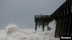 Waves crash along a pier as Hurricane Michael approaches Panama City Beach, Florida, Oct. 10, 2018.