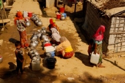 Women line up to fill containers with drinking water at the Rohingya refugee camp in Teknaf, Bangladesh on Feb. 12, 2020. (Hai Do/VOA)