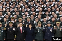FILE - South Korean President Park Geun-Hye cheers with new military officers during a military commissioning ceremony at Gyeryongdae, South Korea's main military compound.