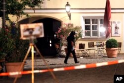 A special police officer examines the scene after an explosion occurred in Ansbach, Germany, Monday, July 25, 2016.