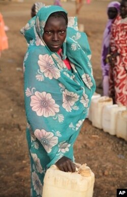 A woman leaving water point with empty jerry can - fights are common as desperation sets in