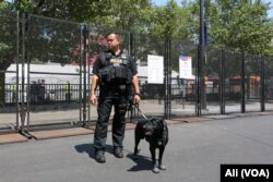 A K-9 officer and his dog stand guard outside the Quicken Loans Arena, where the Republican National Convention is being held, in Cleveland, July 19, 2016.