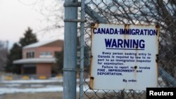 FILE - A sign is seen on a fence in Noyes, Minnesota, March 28, 2017.