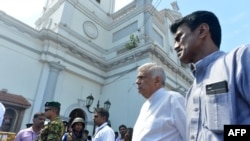 FILE - Sri Lankan Prime Minister Ranil Wickremasinghe (2nd R) arrives to visit the site of a bomb attack at St. Anthony's Shrine in Kochchikade in Colombo on April 21, 2019.