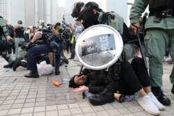 Police arrest a Hong Kong protester after a Chinese flag was removed from a flag pole at a rally in Hong Kong, China, December 22, 2019.