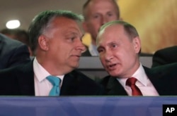 FILE - Russian President Vladimir Putin, right, talks to Hungarian Prime Minister Viktor Orban after arriving at the World Judo Championships in Budapest, Hungary, Aug. 28, 2017.
