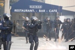 A riot police officer aims at participants of a yellow vests demonstration on Champs Elysees avenue, in Paris, France, March 16, 2019.