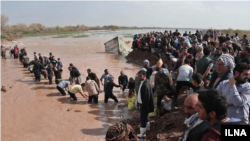 مردم در خوزستان برای نجات دادن زمین‌های زراعی مقابل سیل ایستادند