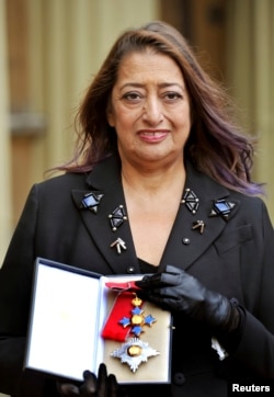 FILE - Architect Zaha Hadid poses for photographs with her Dame Commander of the Order of the British Empire (DBE) medal, after it was awarded to her by Britain's Princess Anne during an Investiture Ceremony at Buckingham Palace, in London, Nov. 7, 2012.