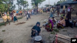 A Rohingya Muslim woman, who crossed over from Myanmar into Bangladesh, cooks food by the roadside near Mushani refugee camp, Bangladesh, Saturday, Sept. 16, 2017. United Nations agencies say an estimated 409,000 Rohingya Muslims have fled to Bangladesh since Aug. 25, following "clearance operations" by Myanmar's military in Rakhine state.