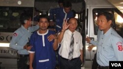 លោក​ម៉ម សុណង់ដូ​ ក្នុង​សំលៀកបំពាក់អាវ​ស​ដៃ​ខ្លី​ ខោ​ពណ៌​ខ្មៅ​មាន​ចង​ក្រវាត់​ក