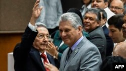 라울 카스트로 쿠바 국가평의회 의장(왼쪽)이 18일 국가인민권력회의에서 의장직을 승계할 미겔 디아스 카넬 수석 부의장 옆에서 손을 흔들고 있다.