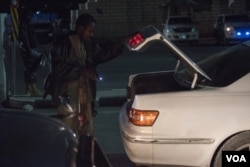 A Somali security officer checks the trunk of a car at a checkpoint in Mogadishu, Sept. 20, 2016. (Photo: J. Patinkin/VOA)