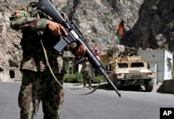 FILE - In this Aug. 27, 2013 photo, Afghan National Army soldiers stand guard on the outskirts of in Kabul, Afghanistan.