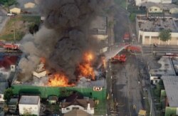 In this April 30, 1992 file photo, a fire burns out of control at the corner of 67th Street and West Boulevard in South Central Los Angeles. On April 29, 1992, four white police officers were declared innocent in the beating of black motorist.
