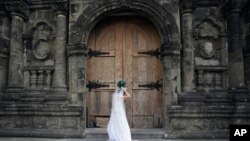 FILE - A Filipino bride arranges her gown before her wedding at a Catholic church in Manila, Philippines.