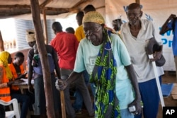 FILE - Kassa Wani and her husband, Alfred, from South Sudan, wait to register with U.N. officials as they arrive at the Busia, South Sudan processing center, March 29, 2017