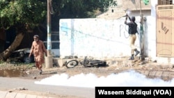 ایک پولیس اہلکار شیلنگ کرتے ہوئے