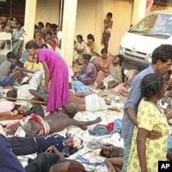 Sri Lankan ethnic Tamil victims of a shell attack wait outside a makeshift hospital in Tiger controlled No Fire Zone in Mullivaaykaal, May 10, 2009