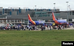 Travelers are evacuated out of the terminal and onto the tarmac after airport shooting at Fort Lauderdale-Hollywood International Airport in Florida, Jan. 6, 2017.