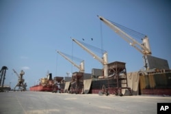 FILE - Cargo ship and oil tanker ship are idle at the port of Hodeida, Yemen, Sept. 29, 2018.
