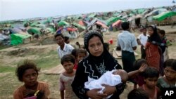 Seorang perempuan muslim Rohingya menggendong bayinya yang lahir di kamp penampungan sementara (foto: dok). Banyak anak-anak di kamp-kamp pengungsian tidak bersekolah lebih dari setahun.