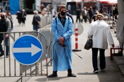 GEORGIA -- A man wearing a protective face mask waits to disinfect carts at a street market in Tbilisi, April 27, 2020