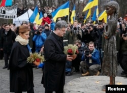 Ukraine's President Petro Poroshenko and wife Maryna place flowers at a monument for Holodomor victims, in Kyiv, Nov. 22, 2014. Millions died of starvationin the famine of 1932-33.