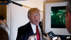 President Donald Trump speaks with reporters on Air Force One while in flight from Andrews Air Force Base, Md., to Palm Beach International Airport, Florida, April 6, 2017.