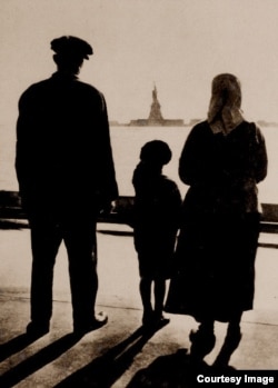 An immigrant family views the Statue of Liberty from Ellis Island