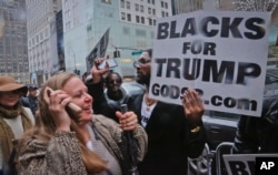 Pedestrians cheer as pro-Trump supporters, gather to voice their support for Trump's election as president, Nov. 9, 2016, outside Trump Tower in New York.