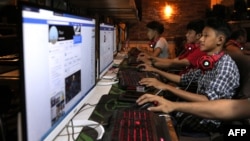 FILE - This picture taken on Dec. 18, 2018 shows Myanmar youths browsing their Facebook page at an internet shop in Yangon.