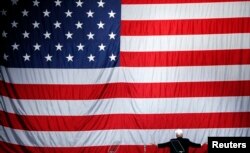 Le républicain Donald Trump se tourne vers le drapeau américain à Sterling Heights, dans le Michigan, le 6 novembre 2016.