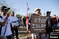 FILE - Demonstrators shout during a "Freedom of Speech Rally Round II" outside the Islamic Community Center in Phoenix, Arizona, May 29, 2015.