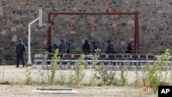 FILE - In this Oct. 8, 2014, photo, police officers take positions by nooses prepared to execute men at a jail in Kabul, Afghanistan. Afghanistan has recently hanged six men convicted of terrorism, signaling a tougher approach toward the Taliban.