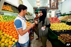 A candidate for parliamentary elections Sahira Falih speaks with a vegetable seller as she campaigns at a market in Baghdad, Iraq, April 20, 2018.