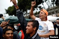 Members of a caravan of migrants from Central America react near the San Ysidro checkpoint as the first fellow migrants entered U.S. territory to seek asylum on Monday, in Tijuana, Mexico, April 30, 2018.