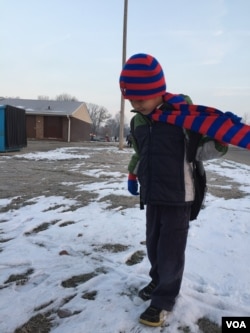 Bu Say Wah waits for his school bus to pick him up. The first-grader is learning English as well as his native language at his Fort Wayne school. His teachers say he is a star pupil and respectful. (C. Presutti/VOA)