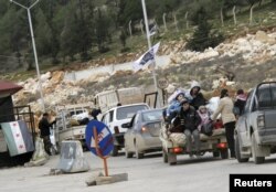 FILE - Syrian refugees wait to cross the border to Turkey at Bab El-Hawa on the outskirts of Idlib, January 13, 2013.