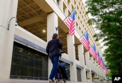 FILE - A person walks in front of the FBI headquarters building in Washington, May 10, 2017.